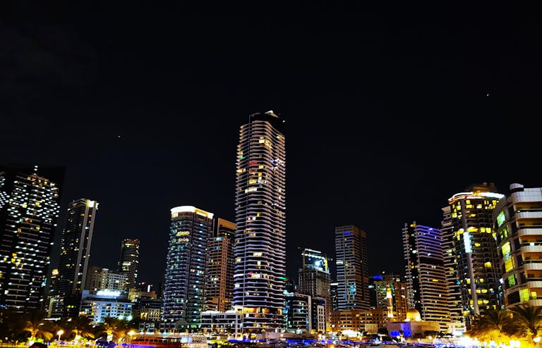 Stunning night view of the Dubai Marina skyline with illuminated skyscrapers reflecting urban vibrancy.